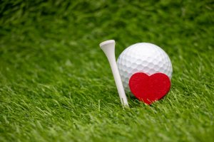 Golf ball with red heart and tee for golfer