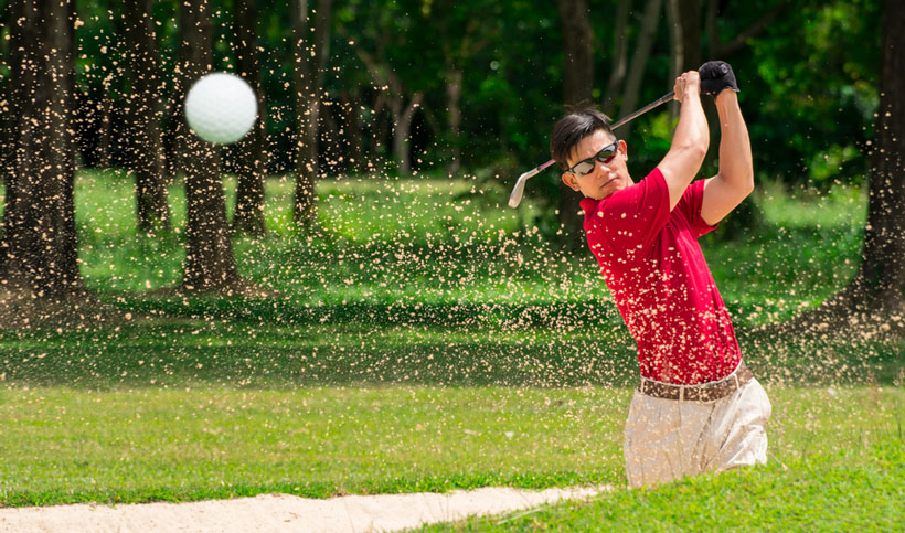 golfer hit golf ball from sand